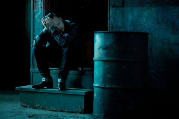 Photo shoot of Aaron Paul in July 2014 on the steps of a shack and near an iron barrel