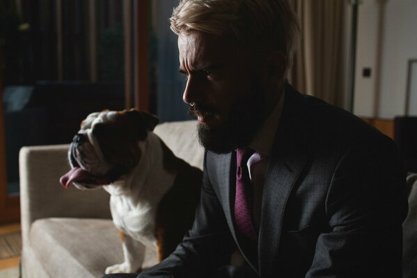 Homme à la barbe en Castille sur le canapé avec un chien