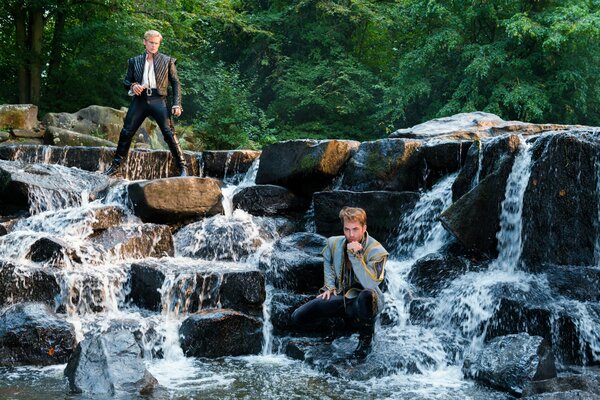 Chicos guapos en las rocas de la cascada