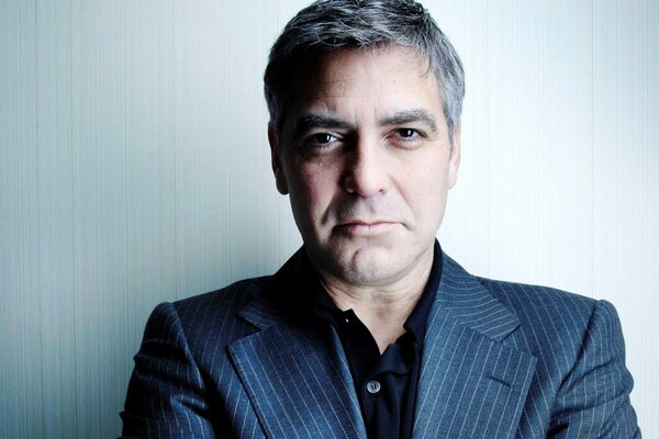 George Clooney trägt ein Jackett mit einem Grinsen und einem Blick