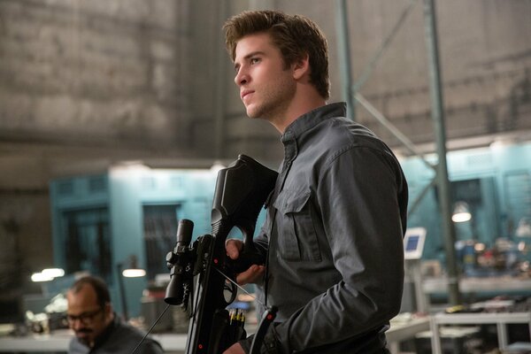 Liam Hemsworth with a rifle in his hands