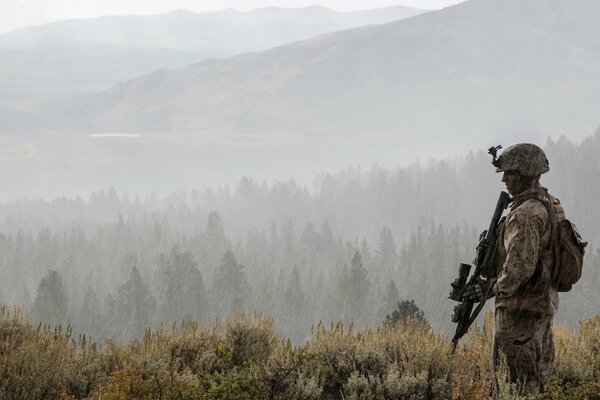 Soldat avec des armes sur fond de forêt