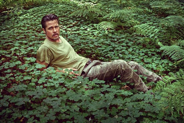 Actor Brad Pitt lies among the green grass