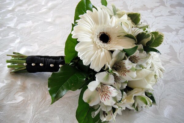 White wedding bouquet of gerberas, alstroemeria on white cloth