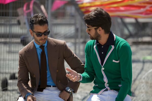 Dos hombres en la calle con gafas hablando