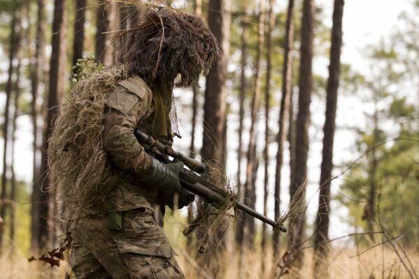 Cecchino con la pistola nella foresta. Esercito