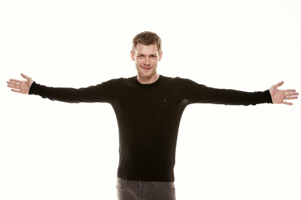 Joseph Morgan in a black sweater on a white background