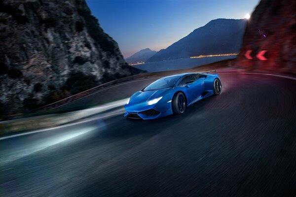 A blue lamborghini on the serpentine road is driving at high speed