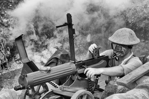 A soldier in a gas mask shoots a weapon