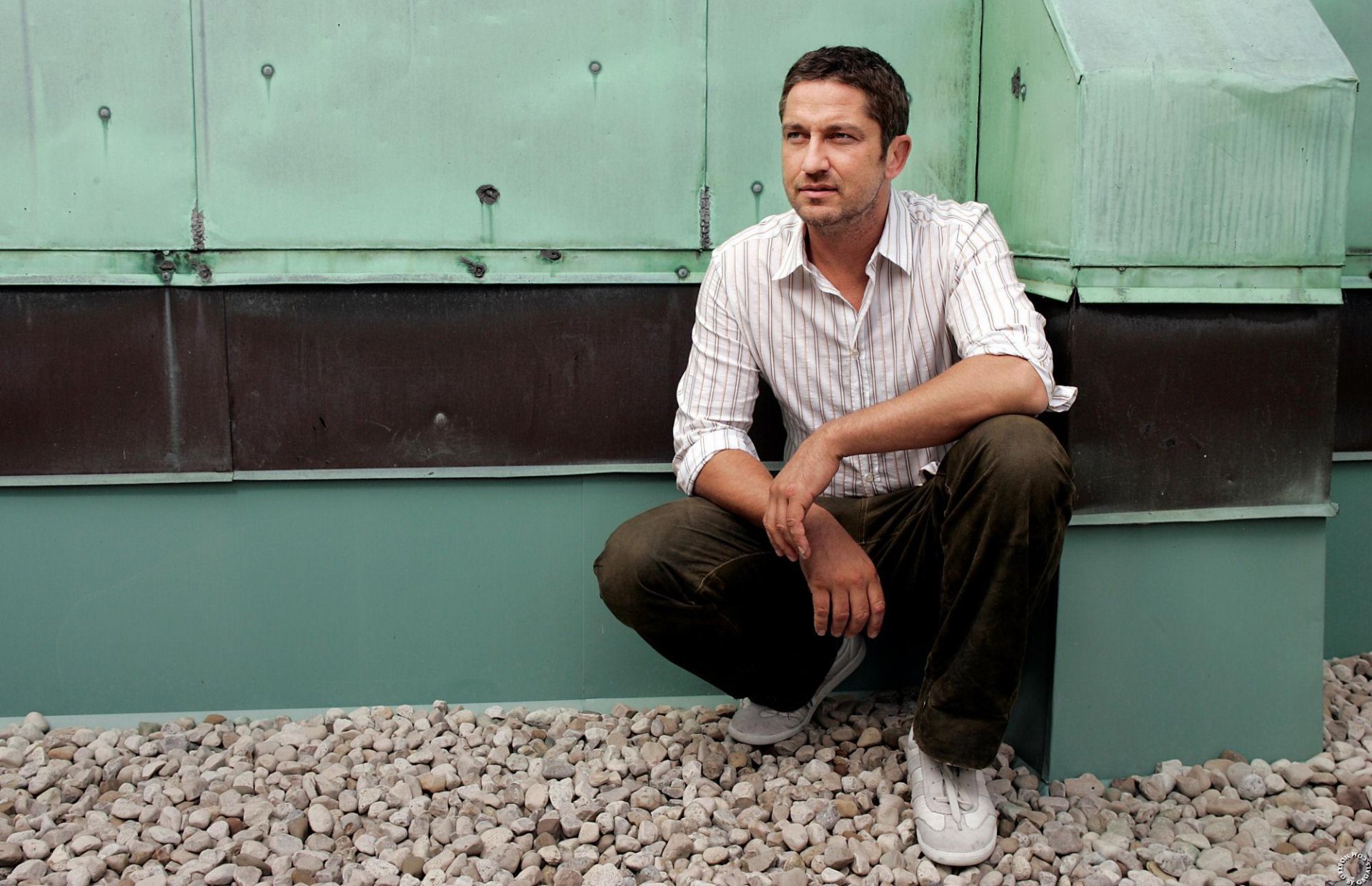 gerard butler accroupi regard cailloux