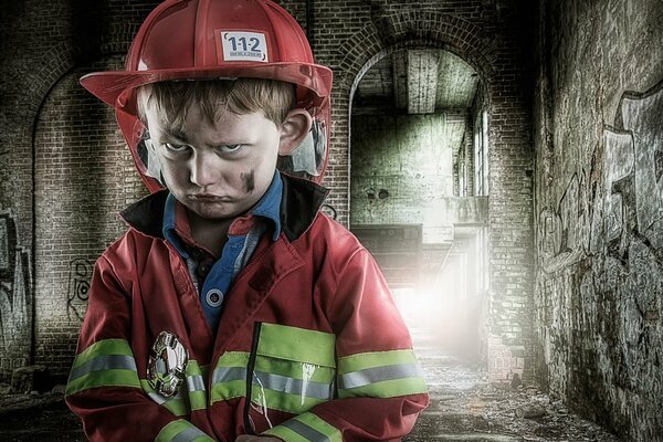 Kleiner trauriger Junge in Feuerwehruniform