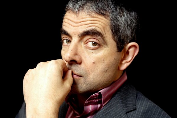 Rowan Atkinson s face on a dark background