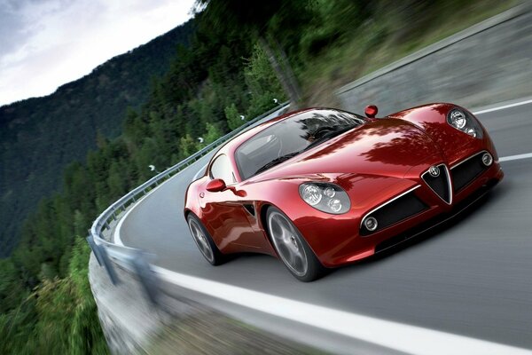 Red Alfa Romeo on the road in the mountains