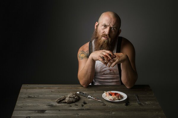 Homme barbu assis à la table et manger