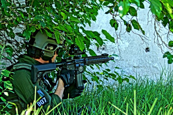 Un homme soldat caché derrière un arbre