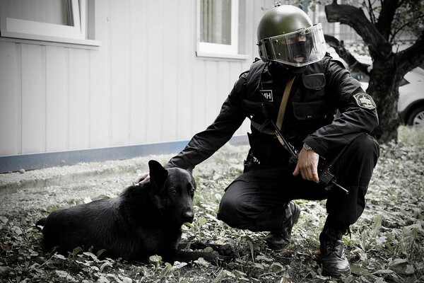 SWAT acaricia al perro. Foto en blanco y negro