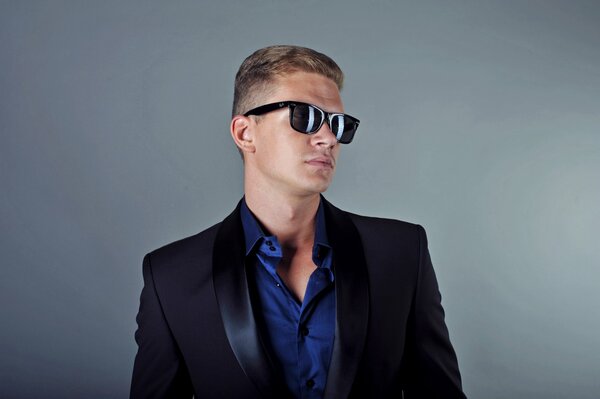 Photo of a man in a tuxedo and dark glasses