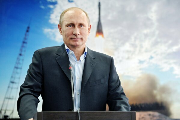 The president stands against the background of a rocket taking off