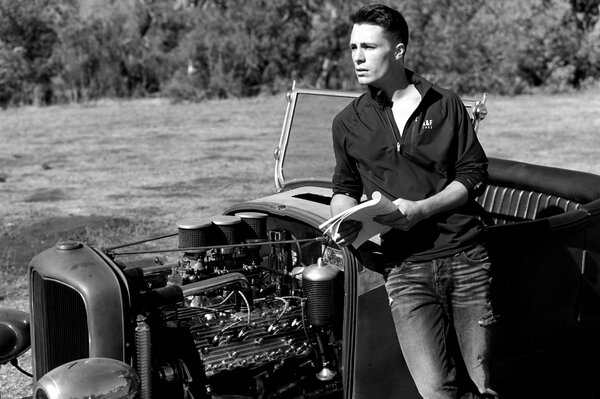 Black and white portrait of a man on the background of a car