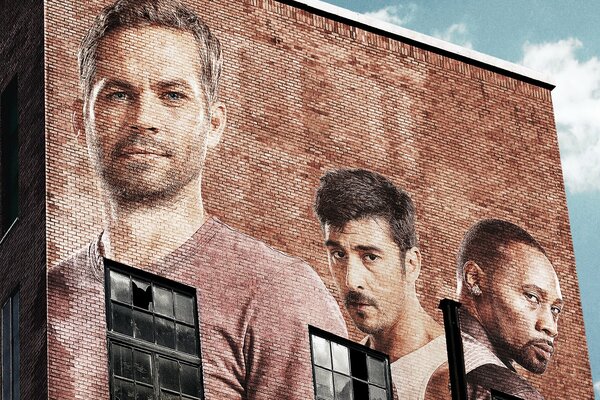 There are portraits of actors of the 13th district on the brick wall