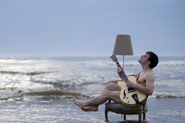 Un hombre toca la guitarra junto al mar