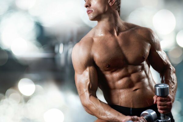 Atleta muscular entrenado con dos mancuernas