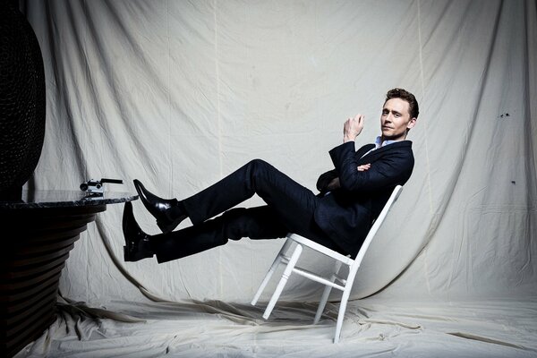 Elegant man on a white leaning chair