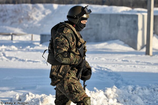 Ein Kommando mit einer Waffe in Uniform auf einem Hintergrund des Schnees