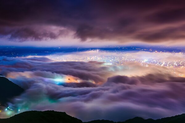 Vuelo sobre las nubes nocturnas y vistas de la ciudad