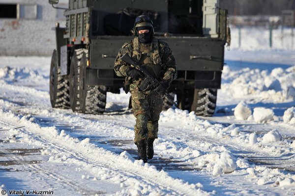 Russische Kommando mit Waffen auf dem Hintergrund eines LKW im Winter