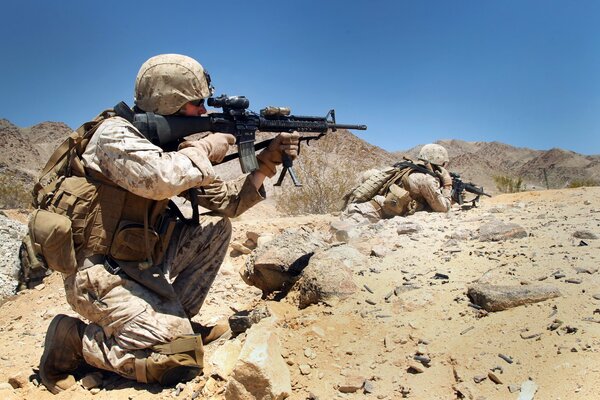 Soldiers with machine guns in the Afghan desert