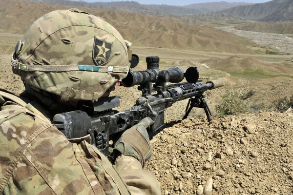 A soldier takes aim from a machine gun