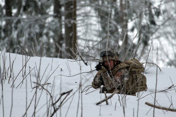 A soldier in the winter forest with a gun