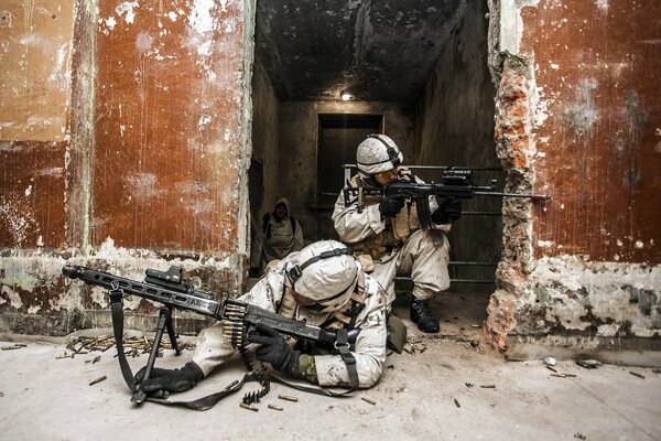 Soldiers in white uniforms shoot from behind a bombarded shelter with a machine gun and a rifle with a sight