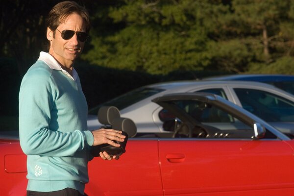 Actor David Duchovny with a red car