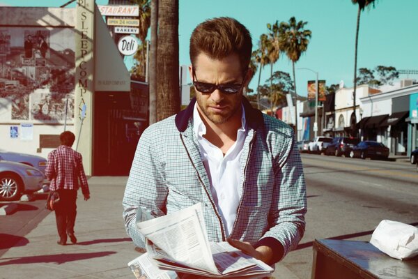 Chris Pine reading the newspaper on the street