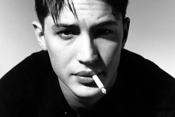 Young Tom Hardy smokes a cigarette