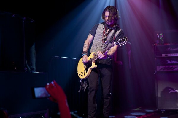 A handsome man with a guitar at a concert