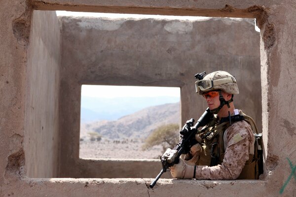 Soldat mit Waffen auf Wandhintergrund