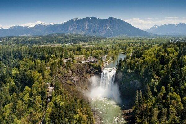 Spektakuläre Aussicht auf den Wasserfall von oben zwischen Bergen und Wäldern