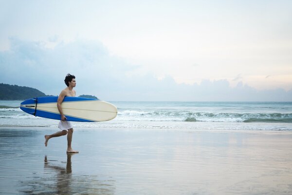 Guy on the beach with a surfboard