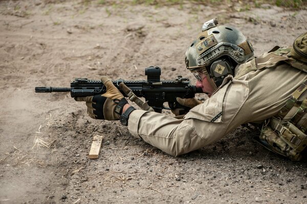 Ein Soldat liegt und schießt aus einer Waffe