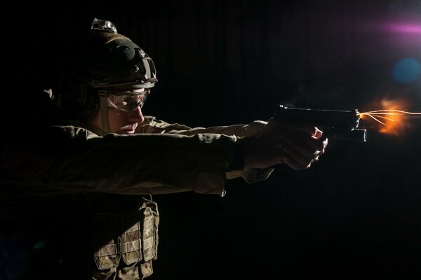 A man in uniform shoots a gun