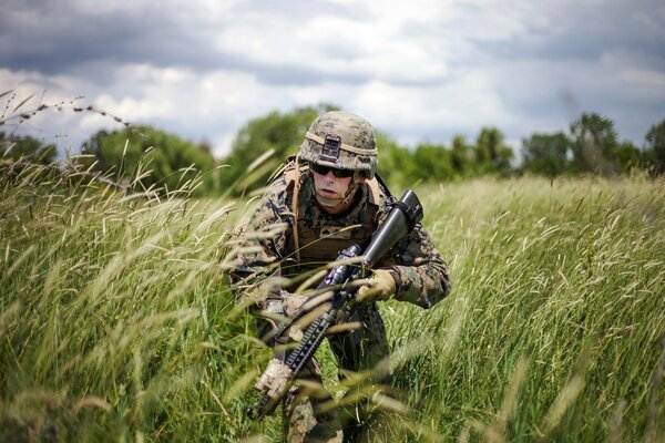 Schönes Militär mit Waffen auf dem Feld