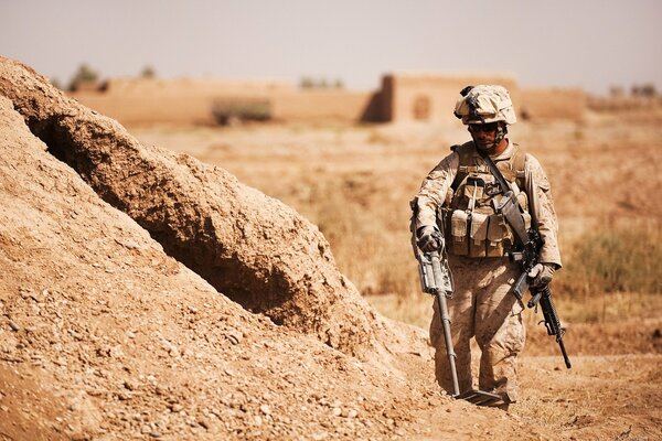 Un soldat dans le désert avec des armes