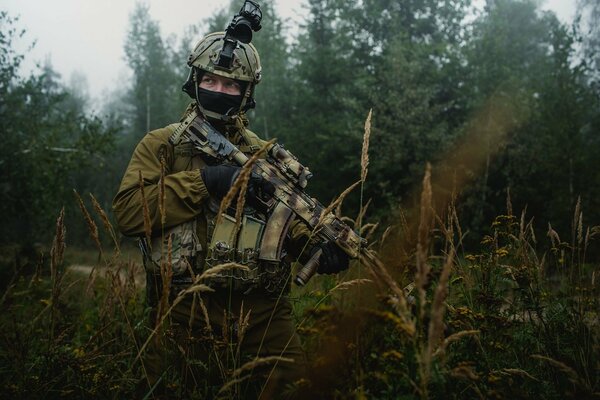 A soldier with a Kalashnikov assault rifle in the forest