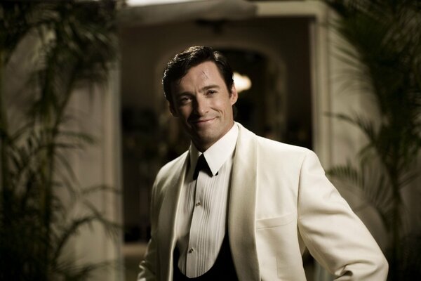 Hugh Jackman smiles in a white suit