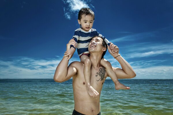 Father and son on their shoulders at sea