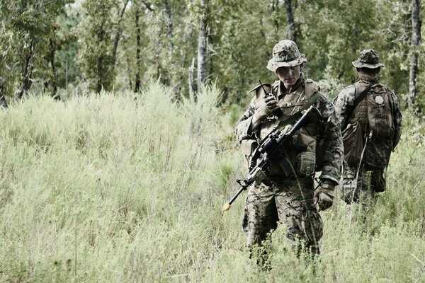 Soldiers in the field with weapons in their hands