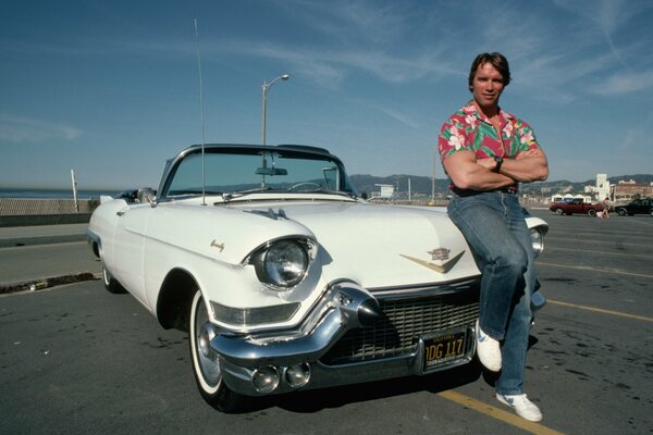 Arnold Schwarzenegger in stile vintage vicino alla macchina